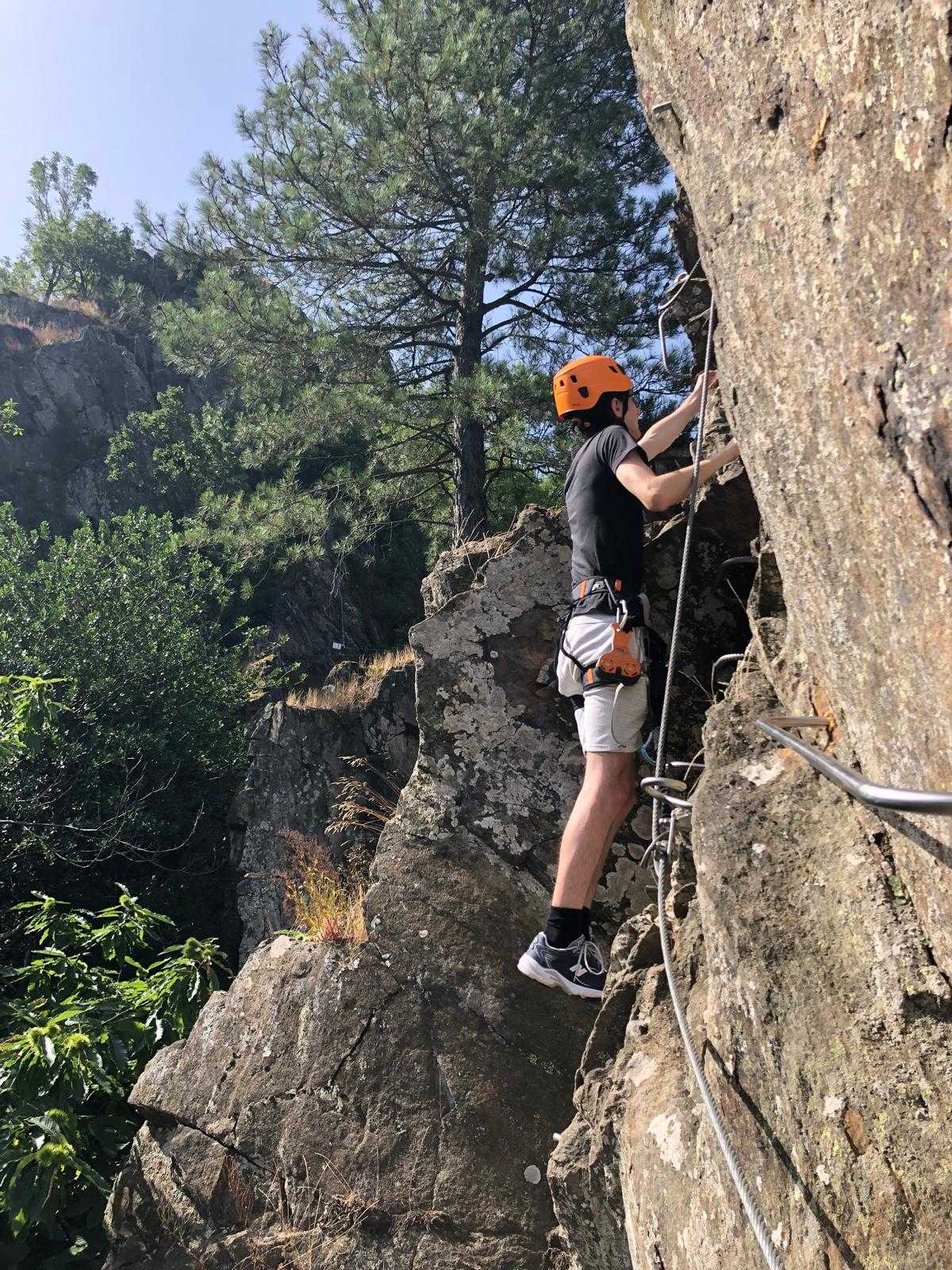 A young man having un on the Passerelle de Mazamet via ferrata protected climbing course